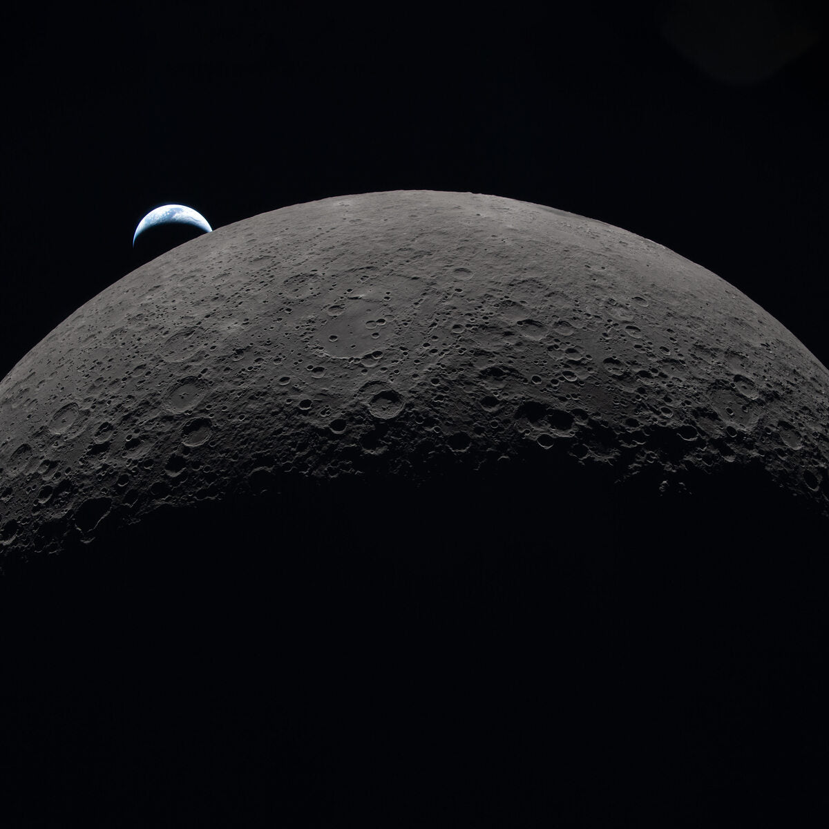 The Moon's curved limb with Orientale basin and Hertzsprung Basin visible, Earth setting on the horizon, photographed by Artemis II